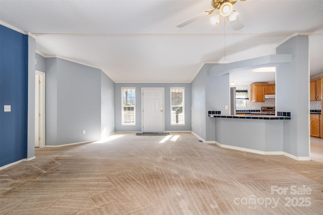 unfurnished living room featuring ceiling fan, crown molding, light colored carpet, and lofted ceiling