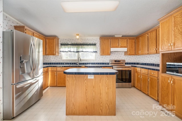 kitchen featuring tile counters, a center island, sink, and stainless steel appliances