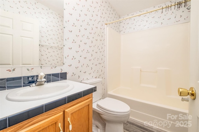 full bathroom featuring vanity, bathtub / shower combination, and toilet