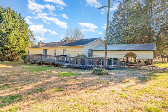 rear view of house featuring a yard, a carport, and a wooden deck