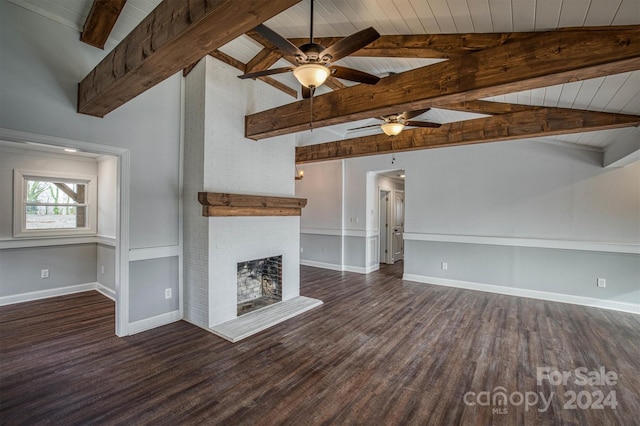 unfurnished living room featuring ceiling fan, dark wood-type flooring, wooden ceiling, a brick fireplace, and lofted ceiling with beams