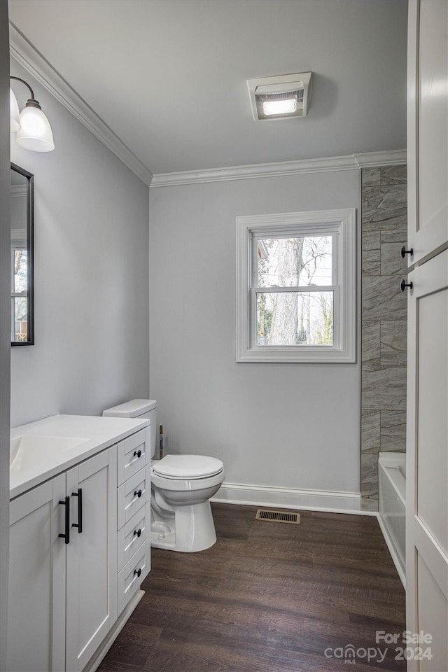 bathroom with crown molding, hardwood / wood-style floors, vanity, and toilet