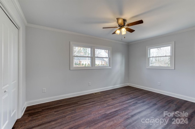 unfurnished bedroom featuring dark wood-type flooring, a closet, ceiling fan, and crown molding