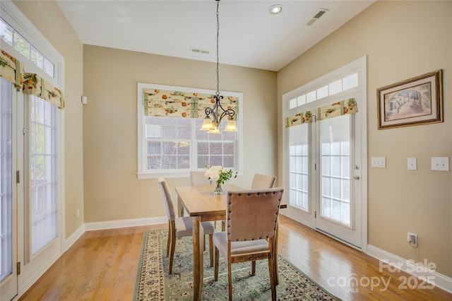 dining area featuring a chandelier and light hardwood / wood-style flooring