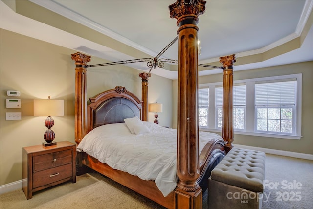 carpeted bedroom with a tray ceiling and ornamental molding