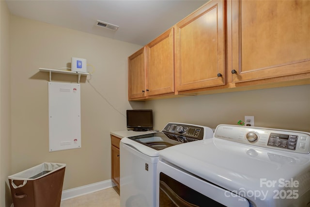 laundry room featuring washing machine and dryer and cabinets