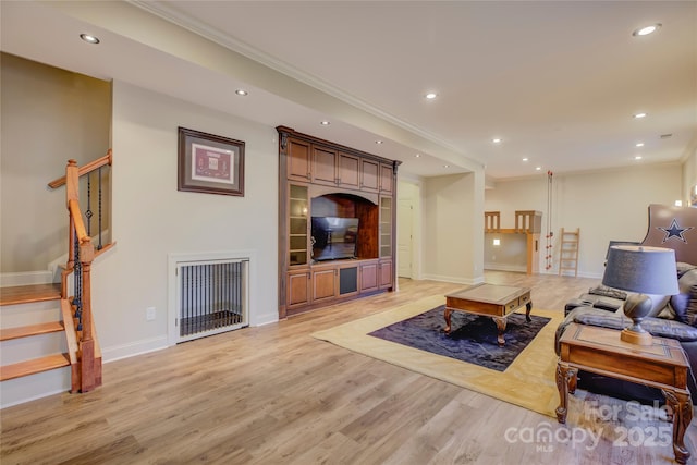 living room with light wood-type flooring and crown molding