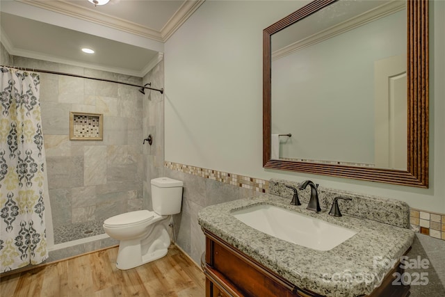 bathroom with a shower with curtain, vanity, ornamental molding, and tile walls