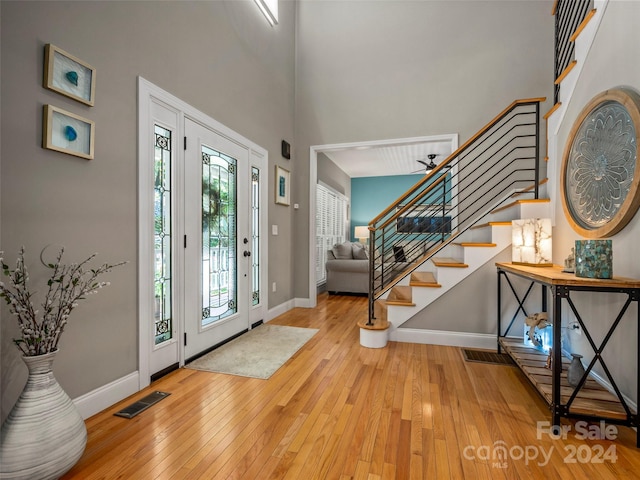 foyer entrance featuring light hardwood / wood-style flooring and a high ceiling