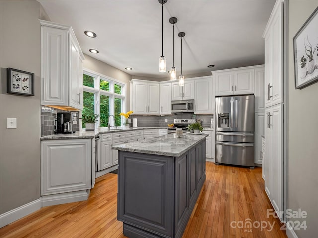 kitchen featuring white cabinets, a center island, and appliances with stainless steel finishes