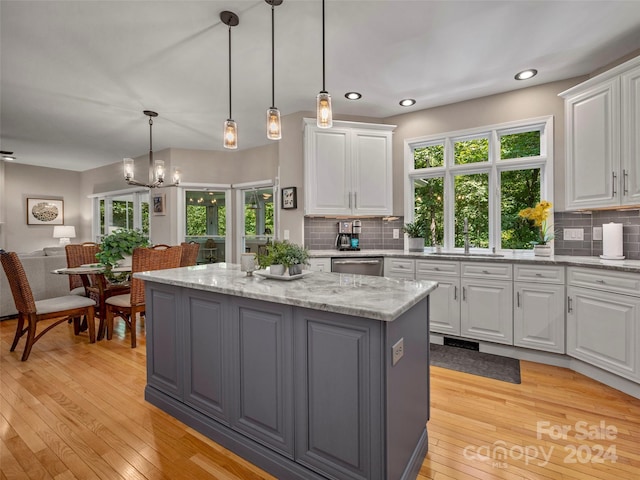 kitchen with white cabinets, pendant lighting, a center island, and decorative backsplash