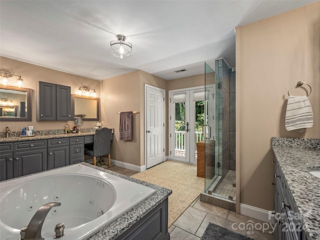 bathroom featuring plus walk in shower, vanity, and tile patterned floors