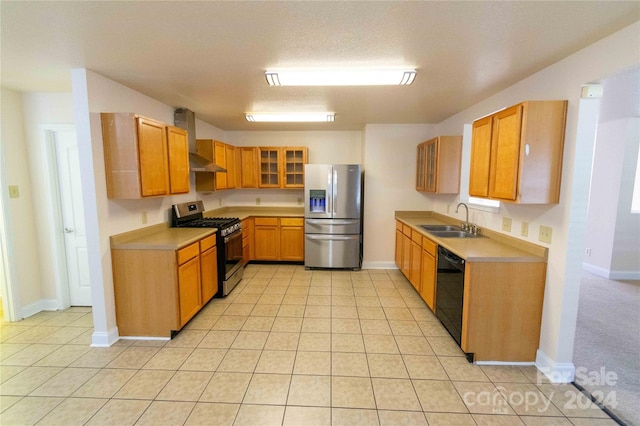 kitchen with sink, wall chimney exhaust hood, a textured ceiling, light tile patterned flooring, and appliances with stainless steel finishes