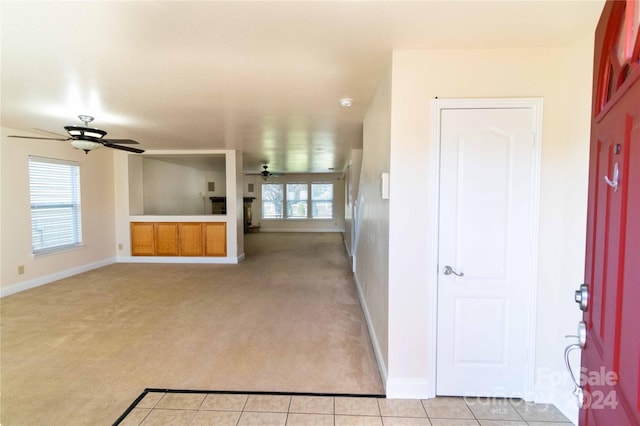 unfurnished living room with ceiling fan, a healthy amount of sunlight, and light carpet