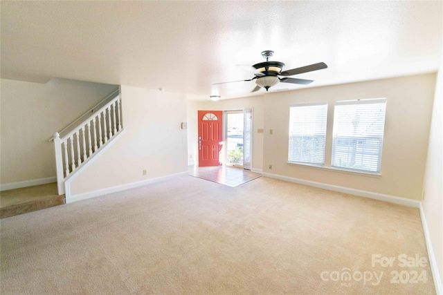 unfurnished living room with light carpet and ceiling fan