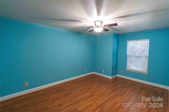 empty room with a textured ceiling, hardwood / wood-style flooring, and ceiling fan