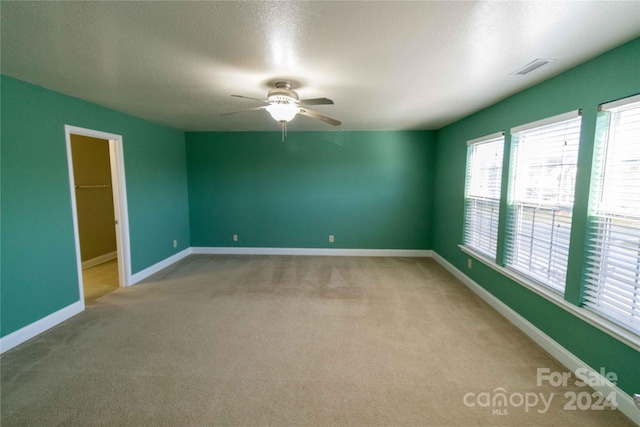 unfurnished room featuring light carpet and ceiling fan