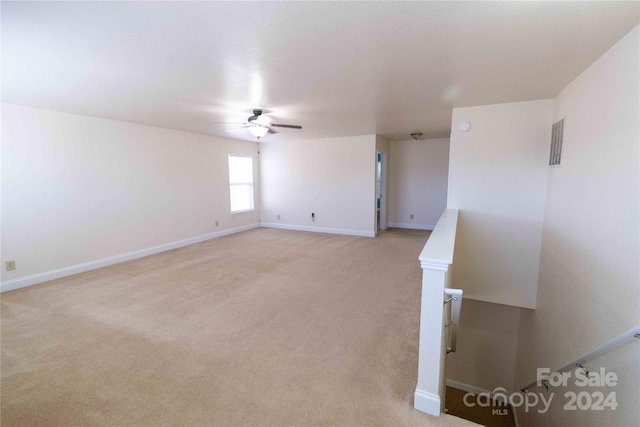 carpeted spare room featuring ceiling fan