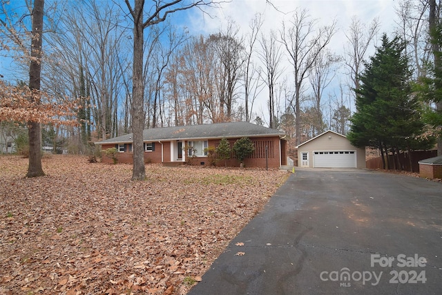 ranch-style house featuring a garage and an outbuilding