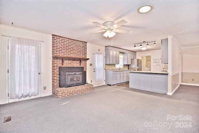 kitchen featuring gray cabinetry, sink, ceiling fan, stainless steel fridge, and a textured ceiling