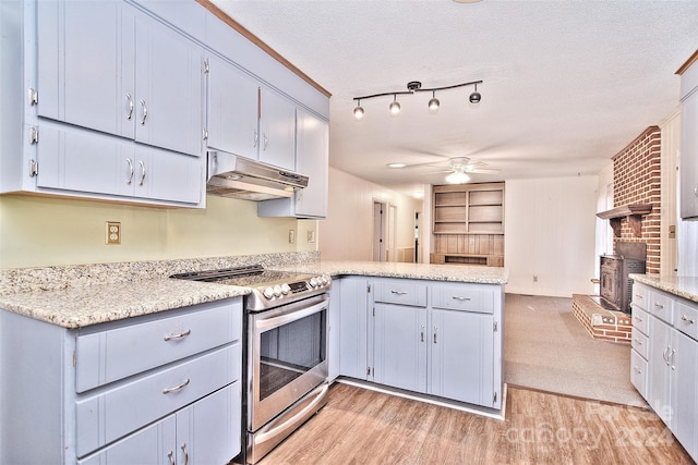 kitchen featuring ceiling fan, kitchen peninsula, light hardwood / wood-style floors, a textured ceiling, and stainless steel range with electric stovetop