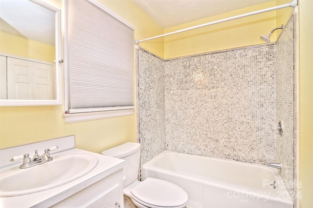 full bathroom with tiled shower / bath, vanity, and toilet