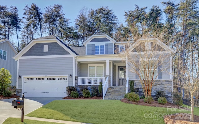 craftsman-style home featuring a garage, covered porch, and a front lawn