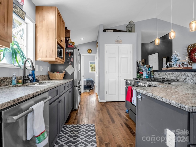 kitchen with pendant lighting, sink, vaulted ceiling, gray cabinets, and appliances with stainless steel finishes