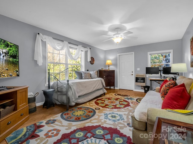 bedroom with multiple windows, ceiling fan, and light hardwood / wood-style floors