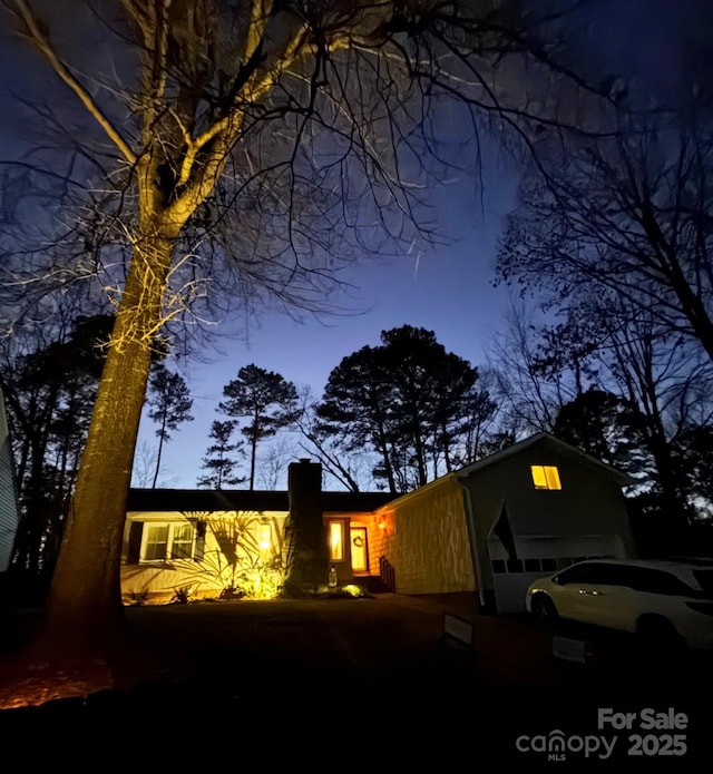 property exterior at dusk featuring a garage