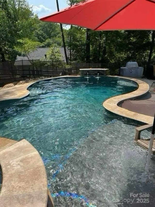 view of pool featuring pool water feature and a patio area