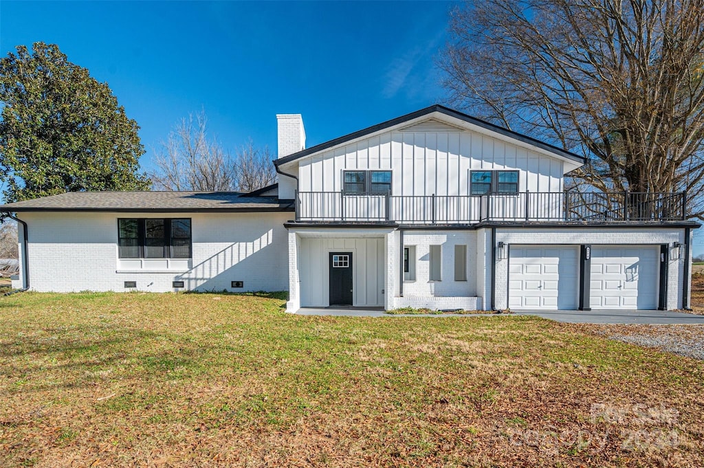 back of property with a garage and a yard