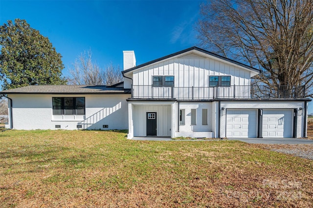 back of property with a garage and a yard