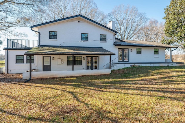 rear view of property featuring a yard and central AC unit