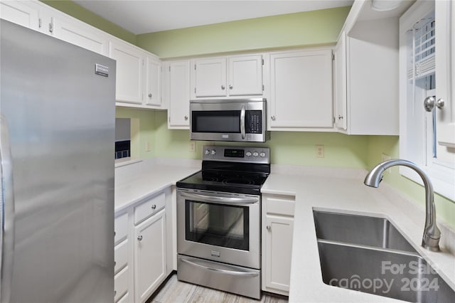 kitchen with white cabinetry, sink, and appliances with stainless steel finishes