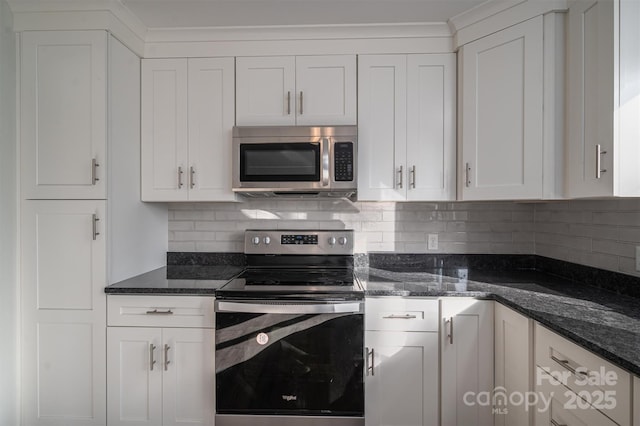 kitchen featuring stainless steel appliances, dark stone countertops, decorative backsplash, and white cabinetry