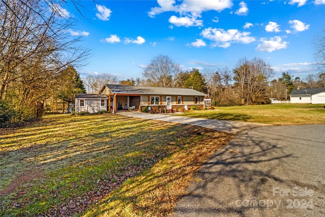 single story home featuring covered porch and a front lawn