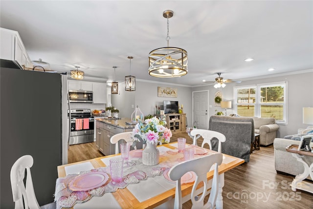 dining area featuring ornamental molding, light hardwood / wood-style floors, and ceiling fan