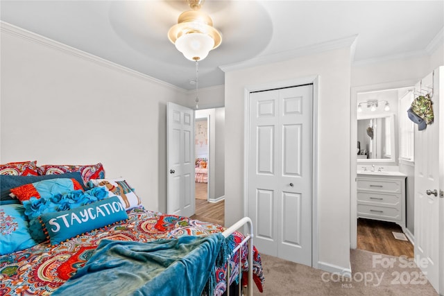 bedroom with ornamental molding, sink, ceiling fan, and a closet