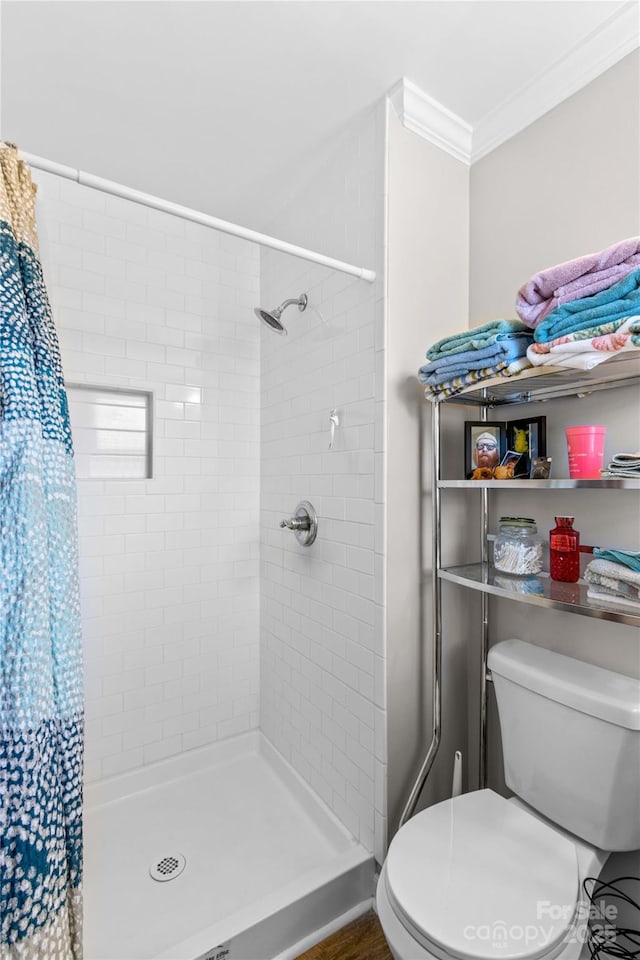 bathroom featuring crown molding, a shower with shower curtain, and toilet