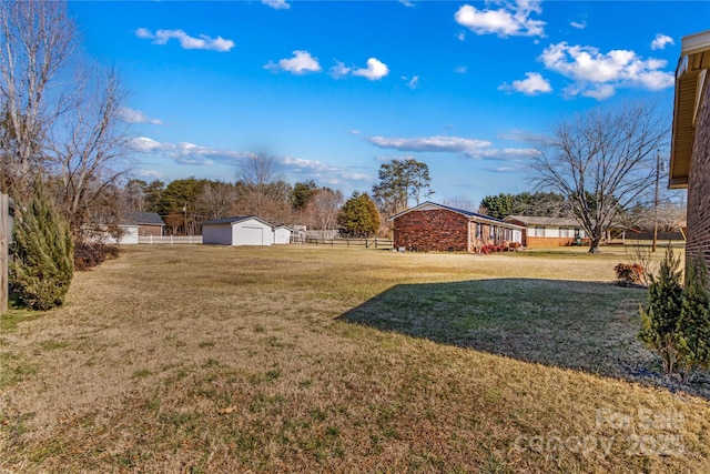 view of yard with a garage and an outbuilding