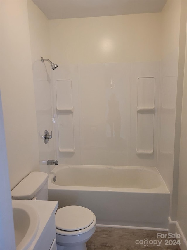 full bathroom featuring washtub / shower combination, vanity, hardwood / wood-style flooring, and toilet