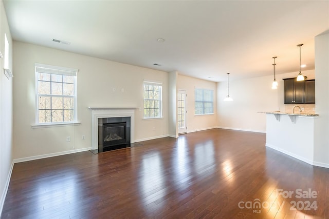 unfurnished living room with dark wood-type flooring