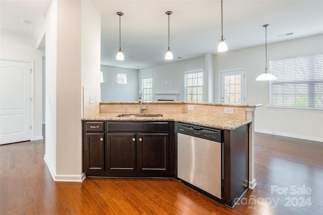 kitchen featuring dishwasher, sink, decorative light fixtures, light stone counters, and dark brown cabinetry