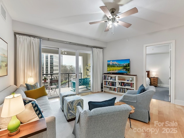 living room with ceiling fan and light hardwood / wood-style floors