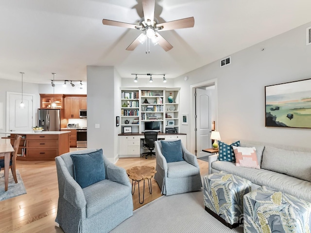 living room with light wood-type flooring and ceiling fan