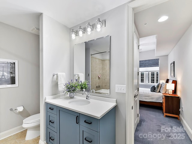 bathroom featuring vanity, toilet, and tiled shower