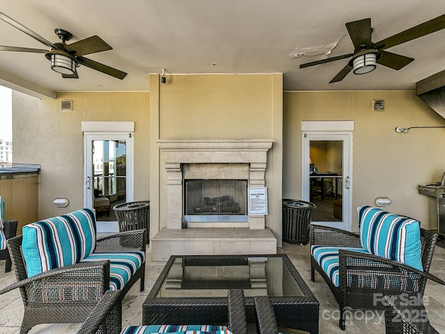 view of patio / terrace with an outdoor living space with a fireplace and ceiling fan