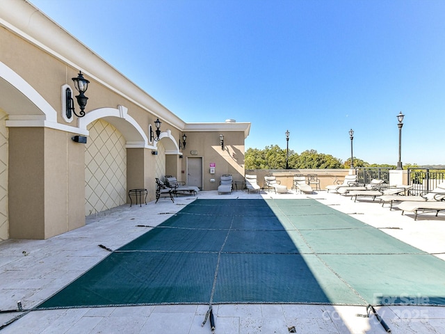 view of swimming pool featuring a grill and a patio