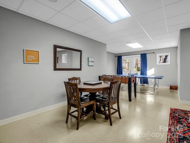 dining room featuring french doors and a drop ceiling